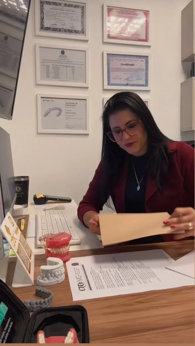Aline Barackat estudando documentos profissionais em seu consultório